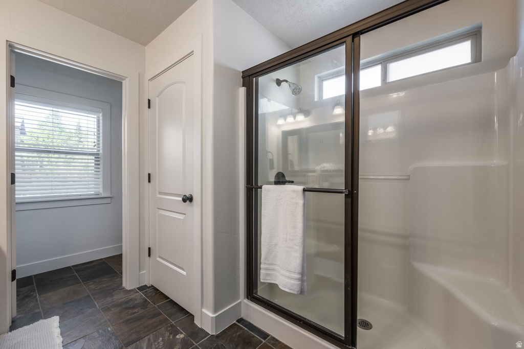 Enclosed shower with a bronze-finish frame, clear glass doors, and a built-in seat