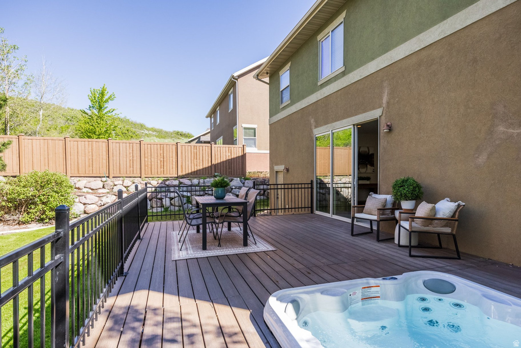 Expansive composite deck featuring an integrated hot tub and durable black metal railing