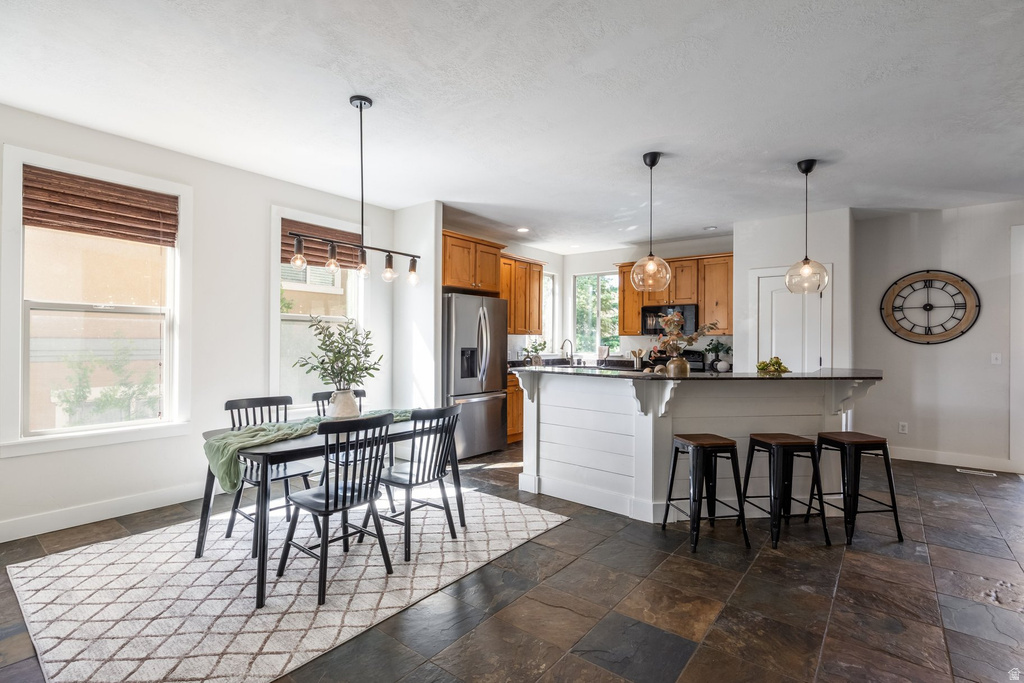 Combined dining and kitchen space featuring dark-toned slate tile flooring