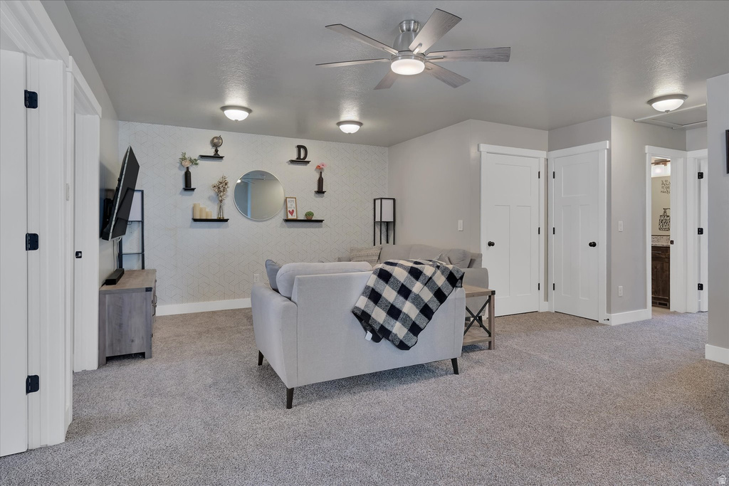 Spacious interior featuring neutral gray carpeting and walls, multiple recessed ceiling lights, and an overhead ceiling fan