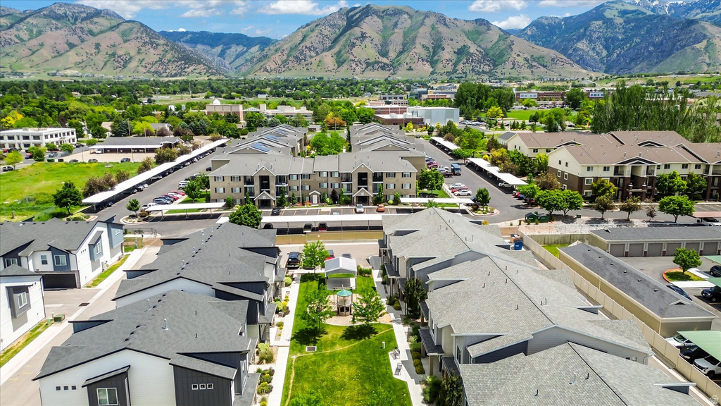 Aerial view of a residential complex featuring multiple buildings with dark gray shingle roofs and varied exterior finishes