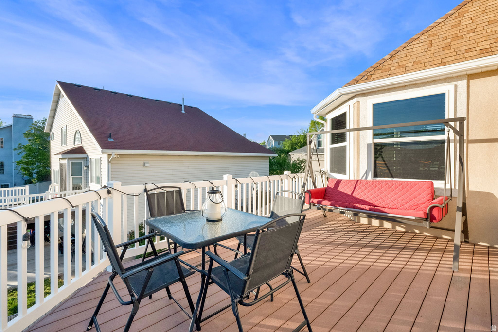 Expansive wood-finish deck featuring white railings and a bay window