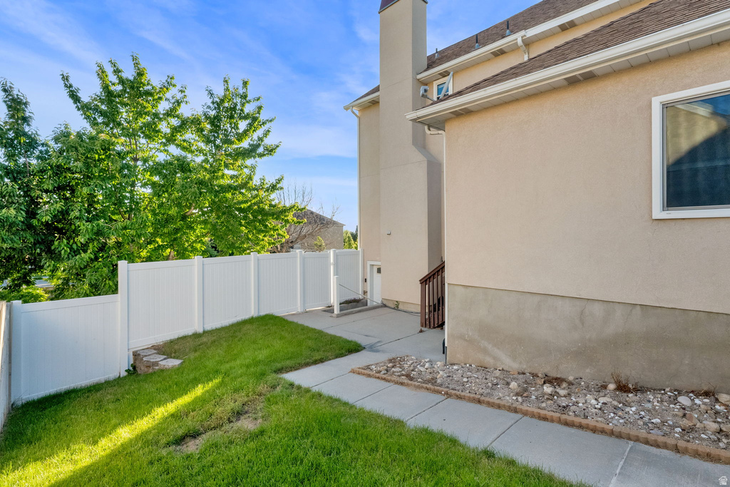 Manicured lawn area featuring a white vinyl fence