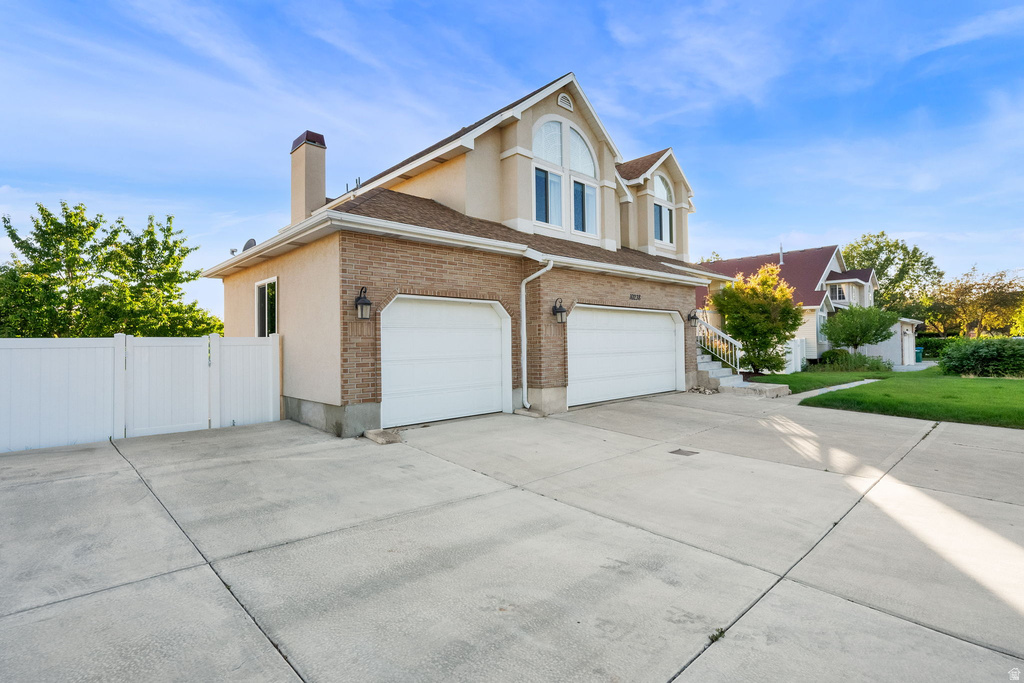 Brick and stucco facade featuring two garage bays with white doors