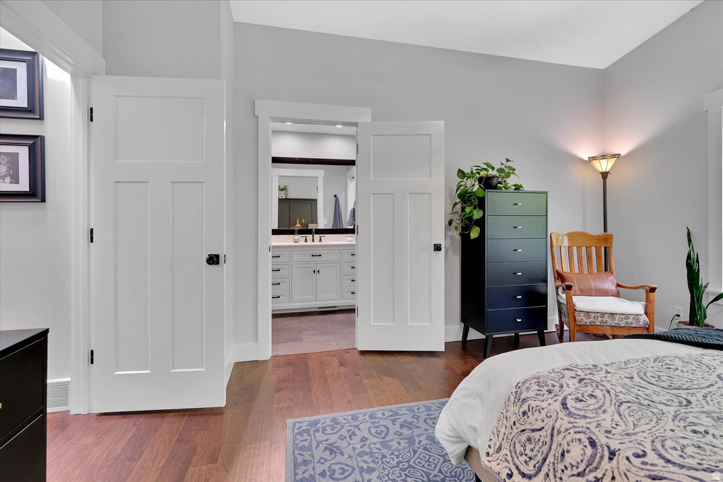 Spacious interior featuring rich wood-finish flooring, light gray walls, and white Craftsman-style doors with dark hardware