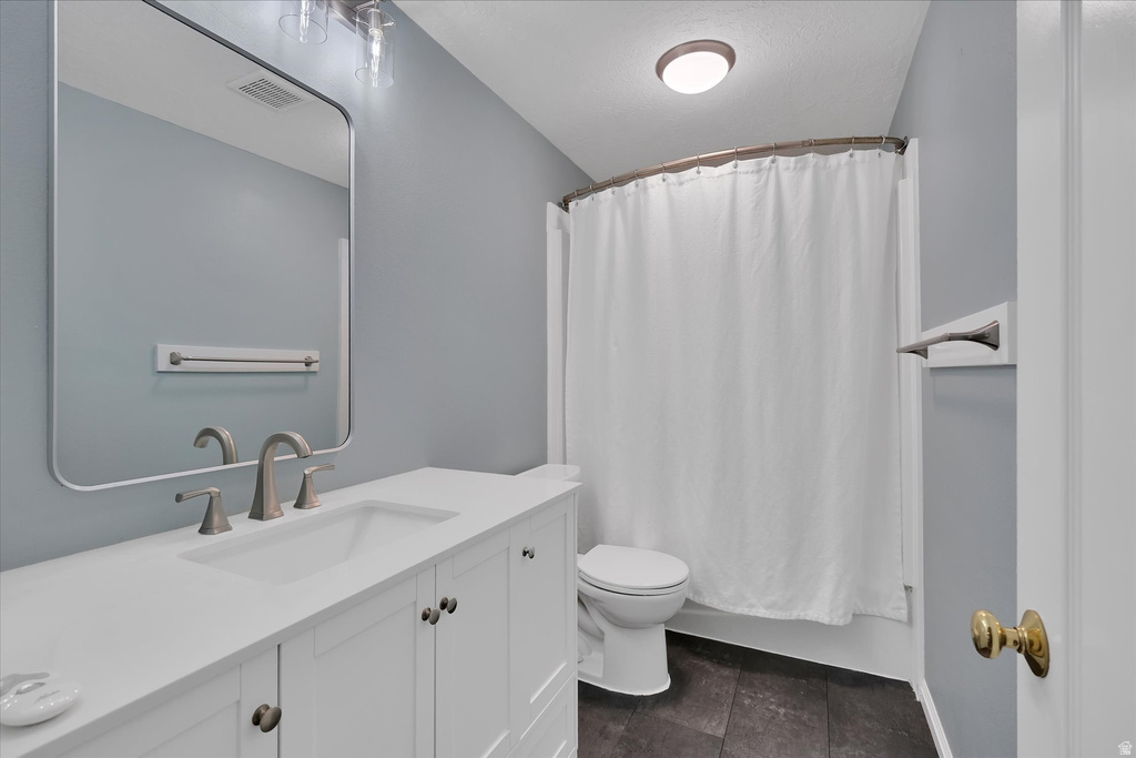 Bathroom featuring a white vanity with brushed nickel hardware, an undermount sink, and a rectangular mirror