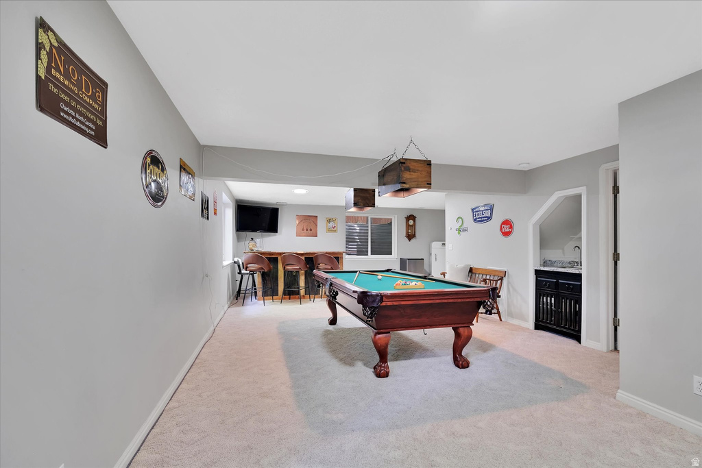 Recreation room featuring a pool table, built-in wet bar, and neutral carpeting