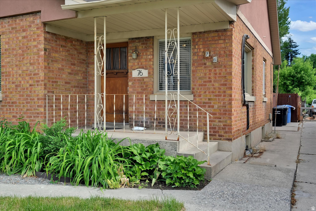 Brick exterior featuring a covered porch with decorative metal railing and support columns