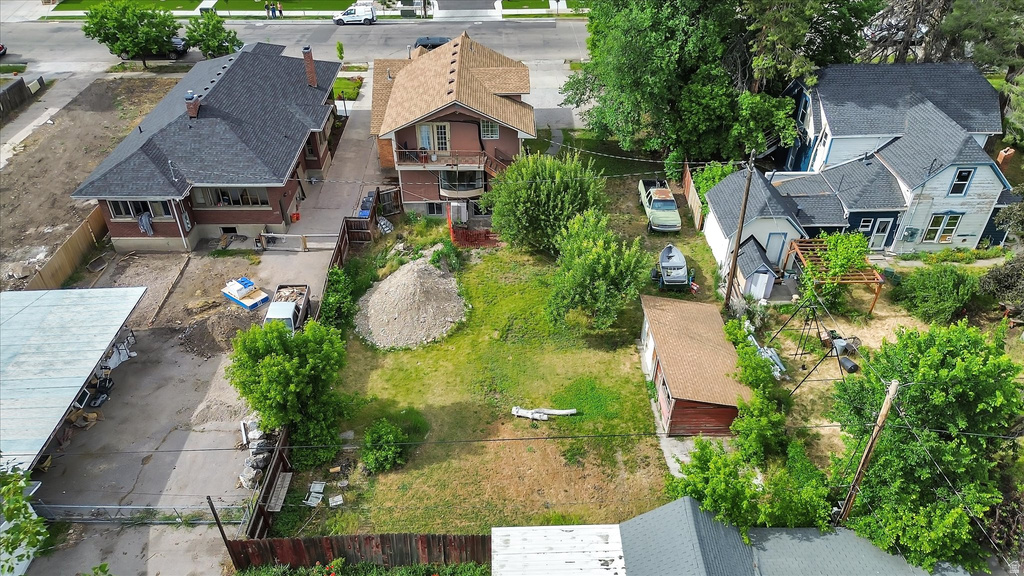 Expansive lot featuring a green lawn, mature trees, and a detached outbuilding with a brown shingle roof