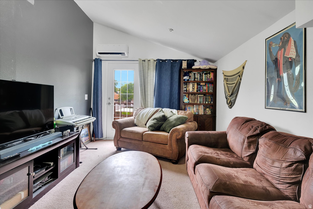 Living area featuring vaulted ceilings, a built-in corner bookshelf, and a glass-paneled exterior door