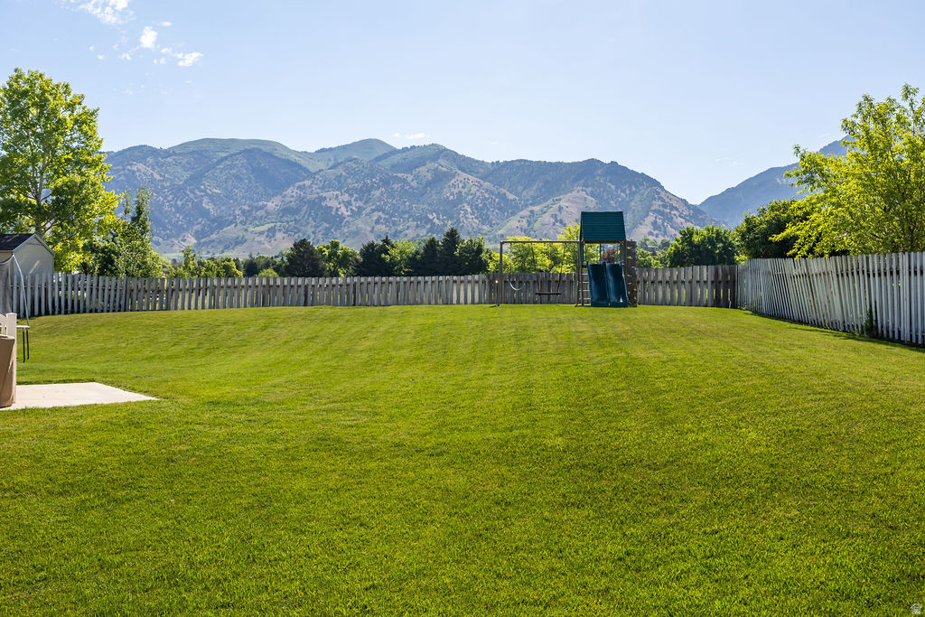 Expansive grassy yard area with a picket fence border