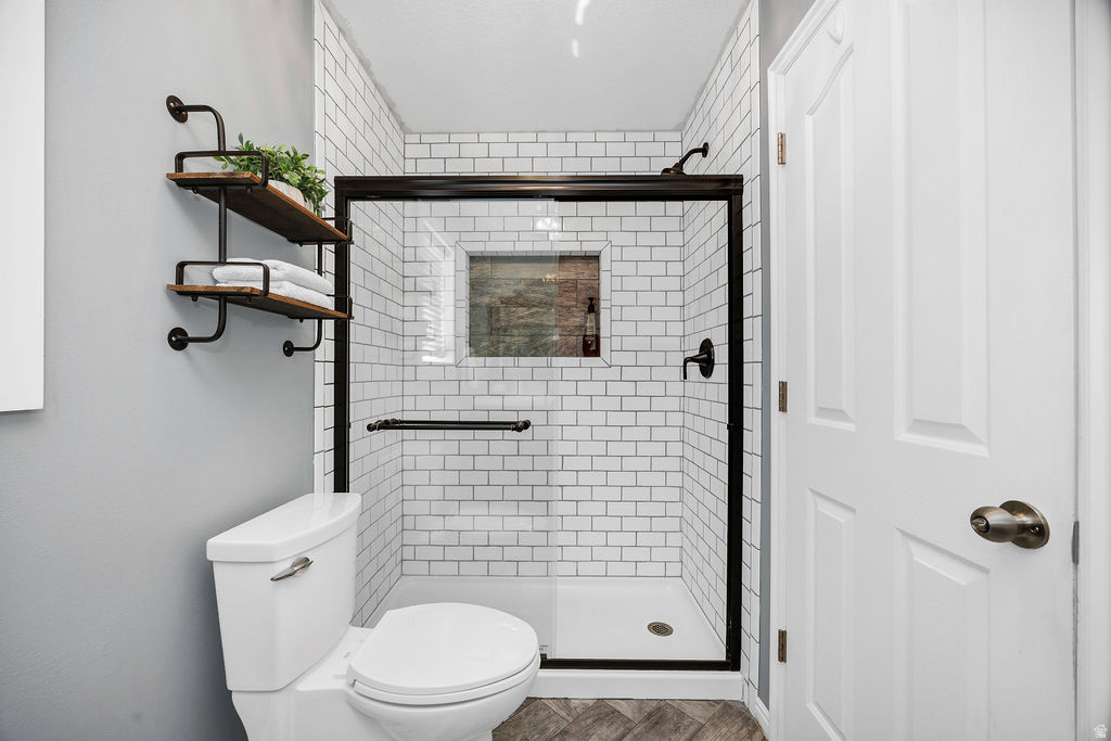 Walk-in shower featuring white subway tile, a dark-framed glass enclosure, and a built-in shower niche