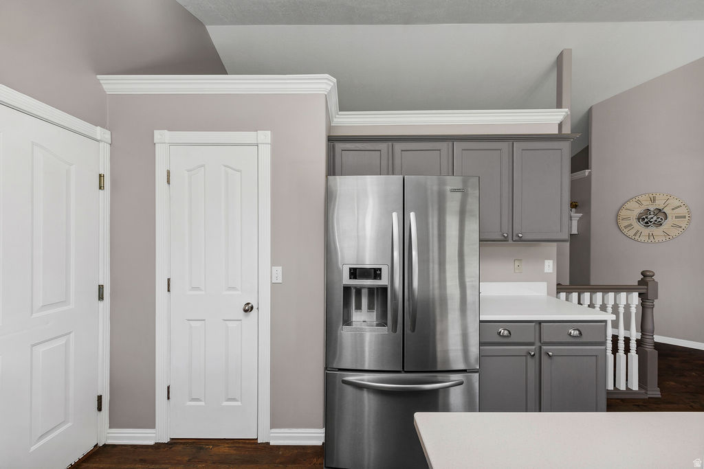 Kitchen area featuring stainless steel refrigerator, gray cabinetry, and white countertops