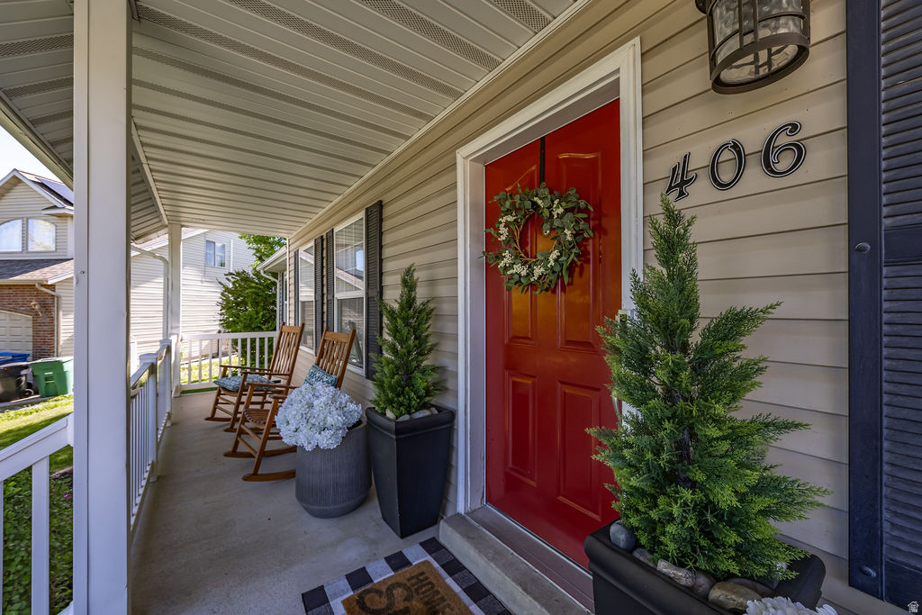 Inviting covered front porch with neutral siding and a vibrant red entry door