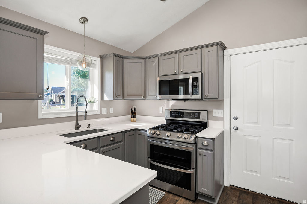 Kitchen featuring gray shaker-style cabinetry, white countertops, and stainless steel appliances
