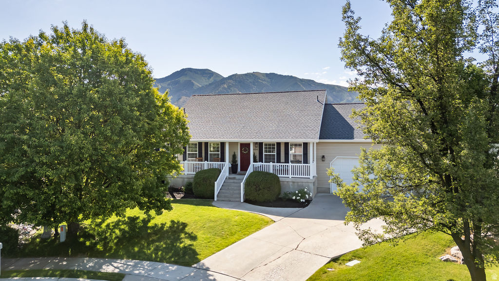 Ranch-style exterior with a covered porch, white railings, and a red front door