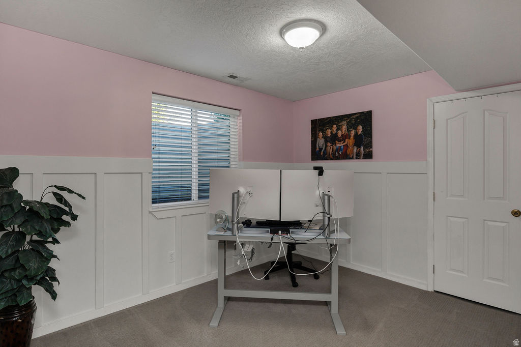 Room featuring white board and batten wainscoting, light pink upper walls, and a window with blinds