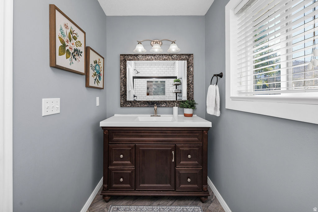 Vanity featuring a white countertop, undermount sink, and dark wood cabinetry