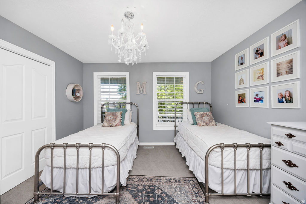 Room featuring two windows with horizontal blinds, recessed lighting, and a crystal chandelier