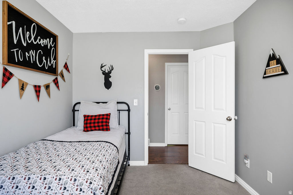 Interior room featuring light gray walls, white baseboards, and gray carpet