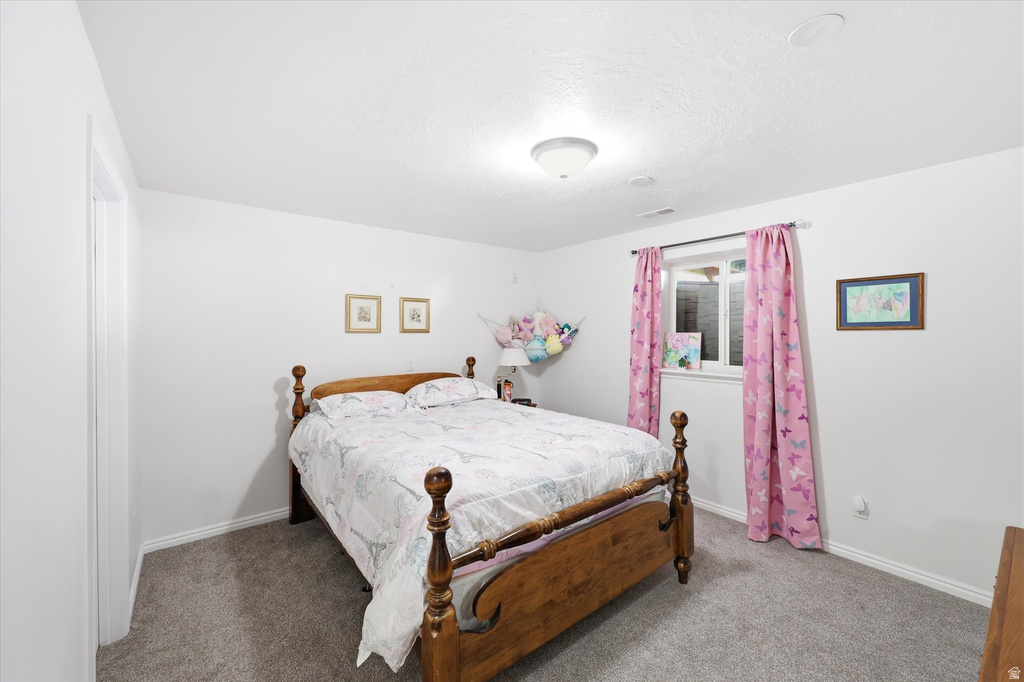 Carpeted room featuring a window with white trim, a flush-mount ceiling light fixture, and white painted walls