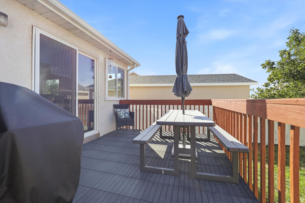 Outdoor deck featuring dark gray modular flooring and brown wooden railings
