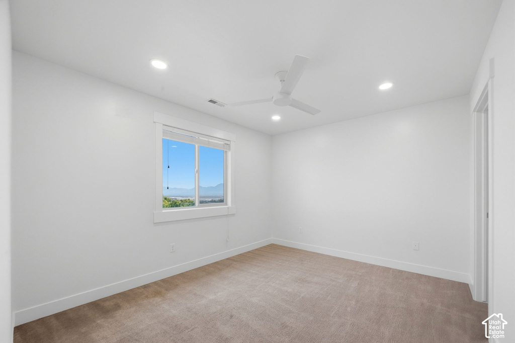Room featuring neutral carpeting, a white ceiling fan, and recessed lighting