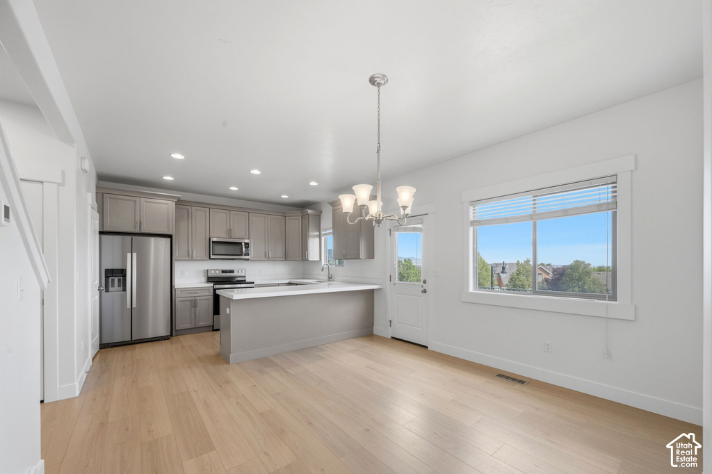 Open-concept kitchen and dining area with light wood-finish flooring