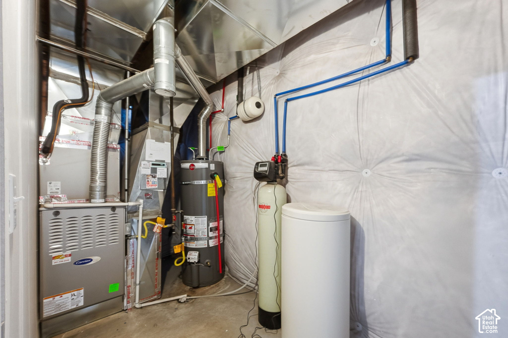Utility area featuring a furnace, water heater, and water treatment system
