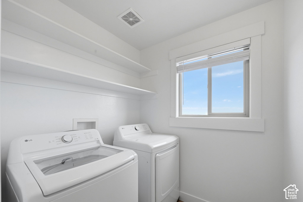 Dedicated laundry area featuring a window, built-in shelving, and a ventilation system