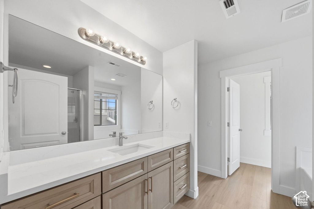 Spacious bathroom featuring an extended vanity with dual-tone cabinetry, a single undermount sink, and a large wall-mounted mirror
