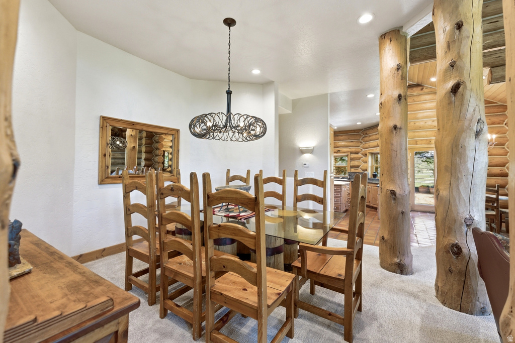 Dining area featuring a decorative chandelier, recessed lighting, and a wood-framed mirror