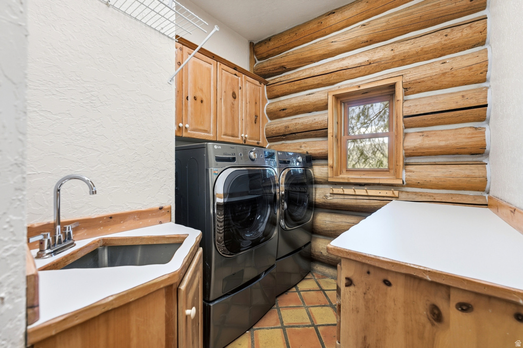 Laundry area featuring exposed log wall construction and tile flooring