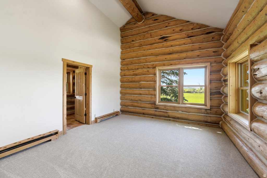 Room featuring exposed log walls, a vaulted ceiling, and light-colored carpeting