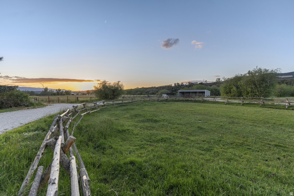 Expansive grassy field bordered by a rustic split-rail fence