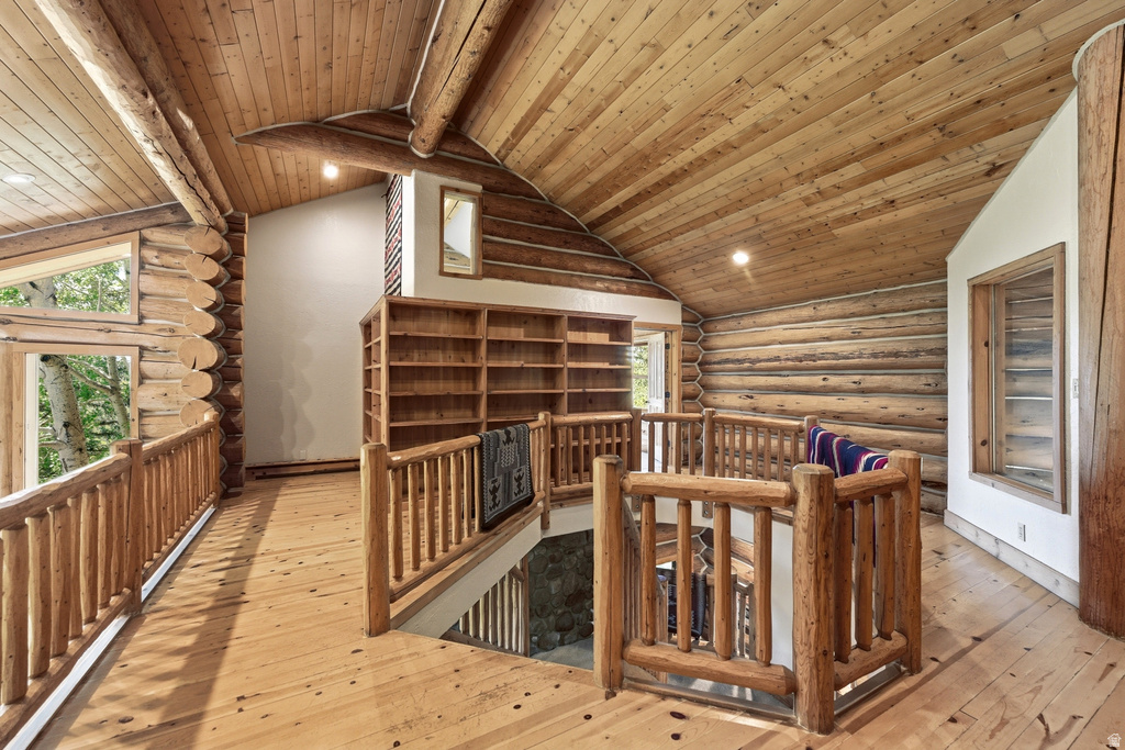 Upper-level landing featuring wood-finish flooring and extensive log construction