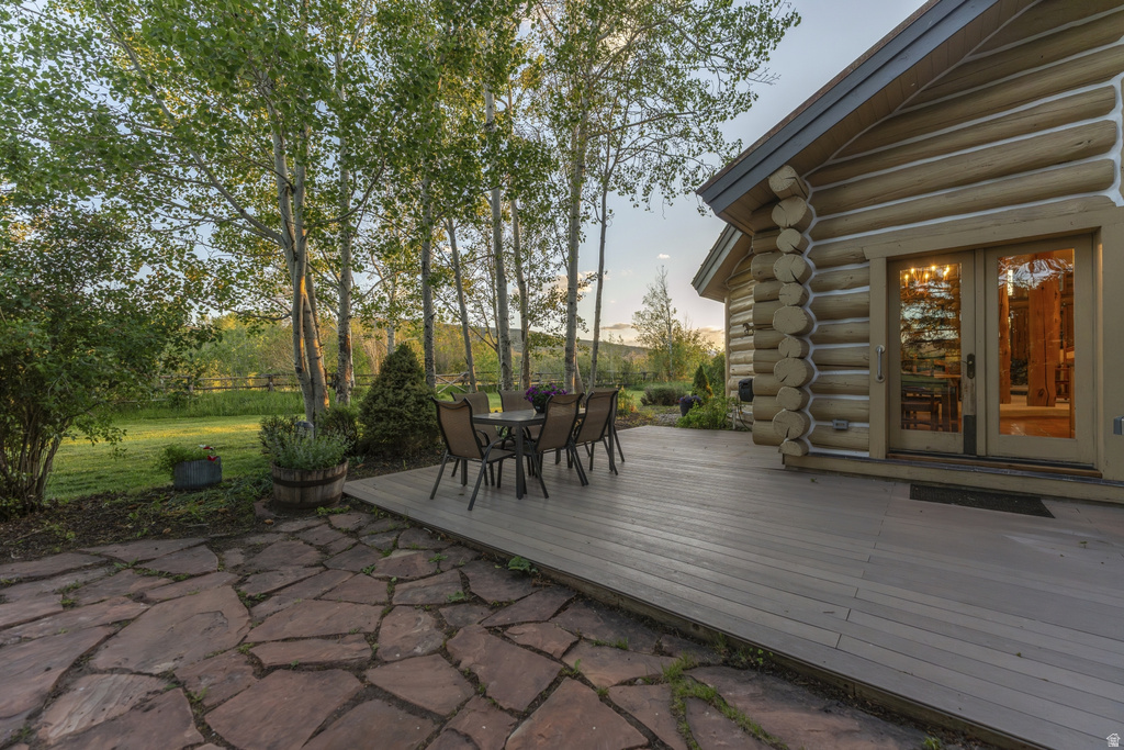 Log cabin exterior featuring a spacious composite deck and flagstone patio