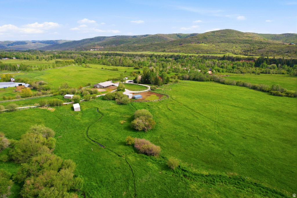 Expansive green acreage featuring a main residence, multiple outbuildings, and a round pen