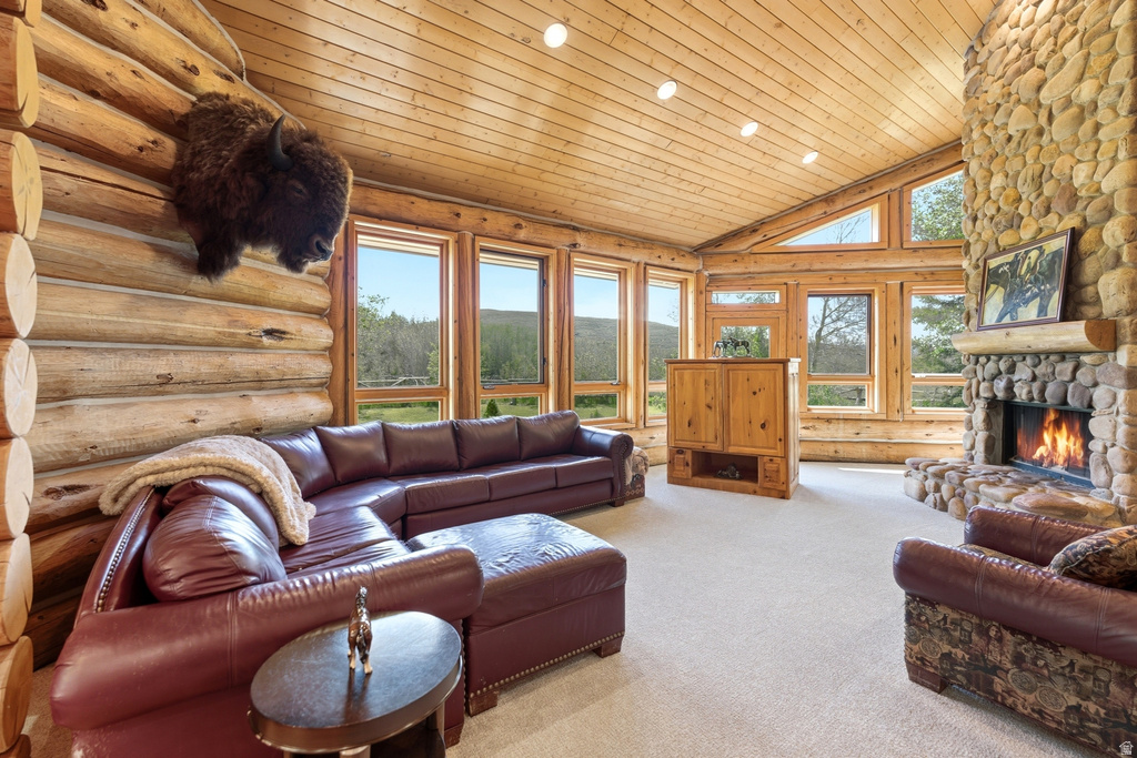Spacious living area featuring log walls, a vaulted wood-plank ceiling, and a prominent stone fireplace