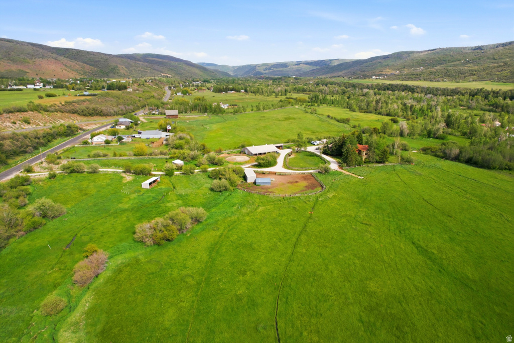 Expansive property featuring verdant fields, a circular driveway, multiple outbuildings, and a main residence surrounded by mature trees