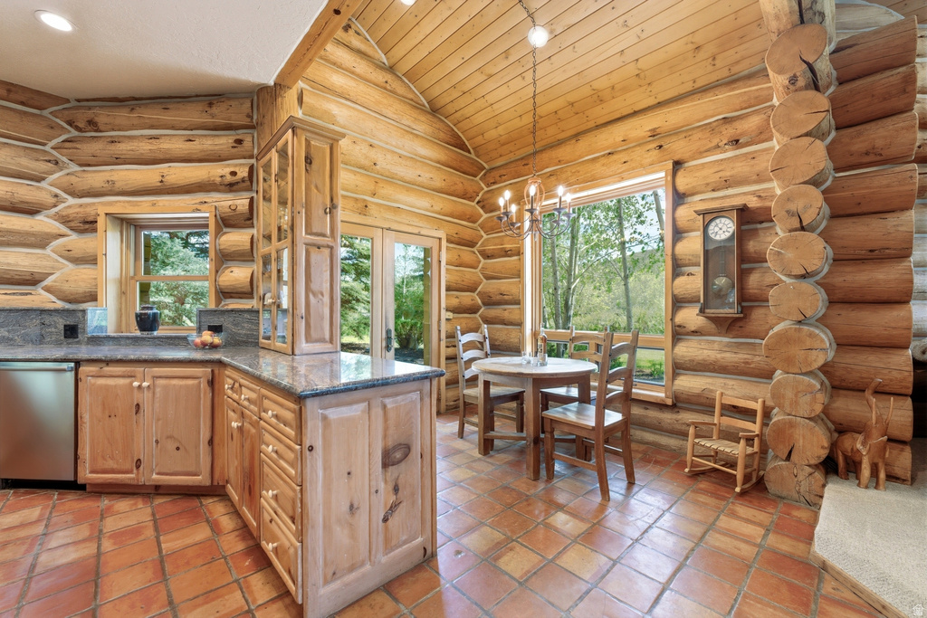 Expansive kitchen and dining area featuring natural log walls, wood-finish cabinetry, and a vaulted wood-paneled ceiling