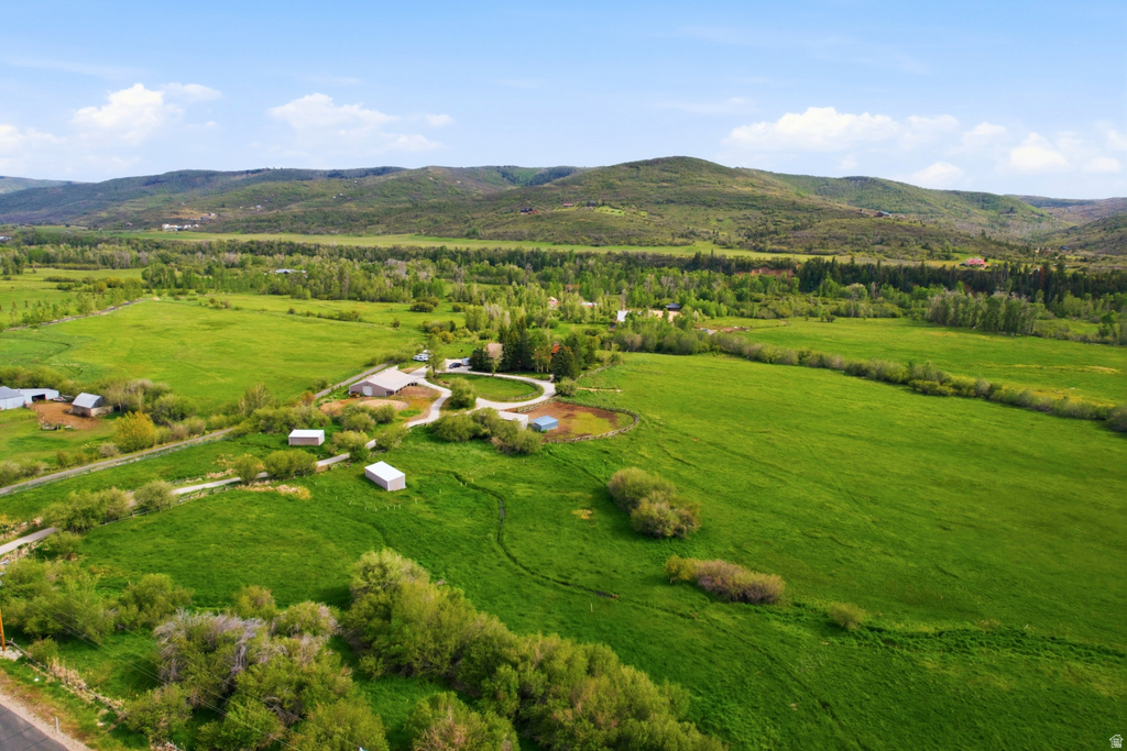 Expansive green fields surrounding a rural property with multiple outbuildings and a central residence