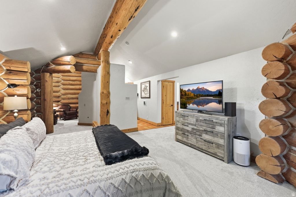 Expansive room featuring log walls and exposed log beams, recessed lighting, and light-toned carpeting