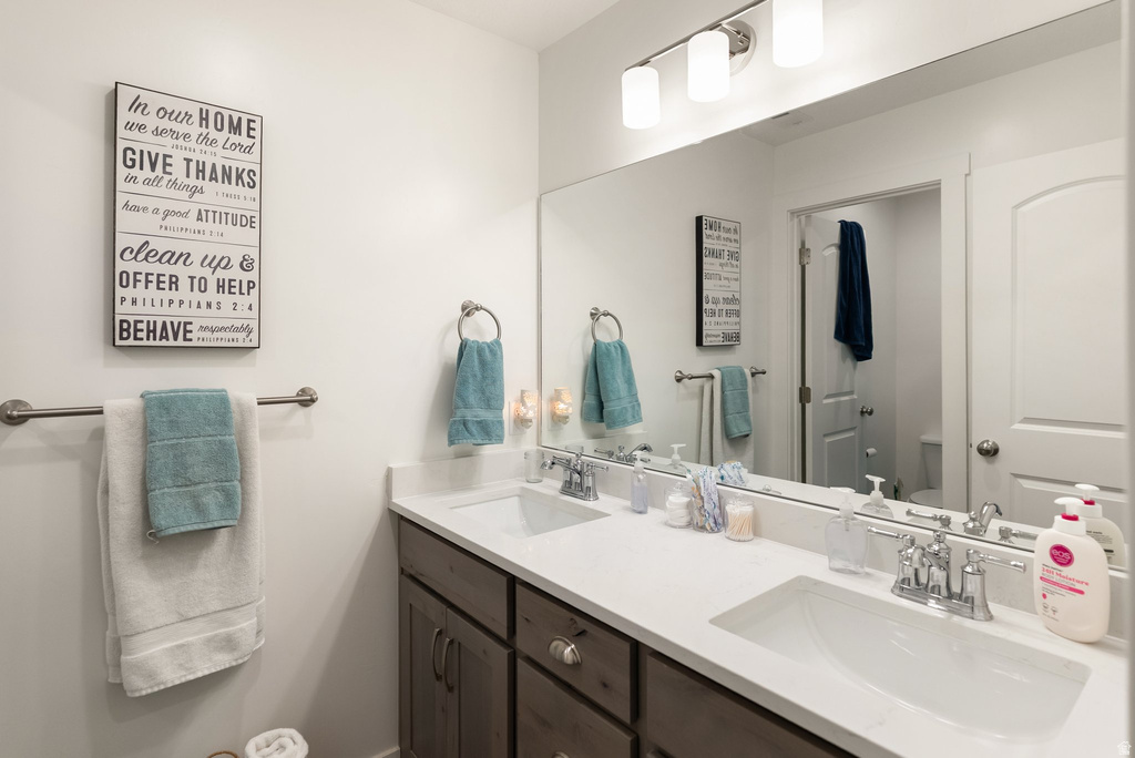 Dual vanity with undermount sinks, chrome faucets, and white countertops