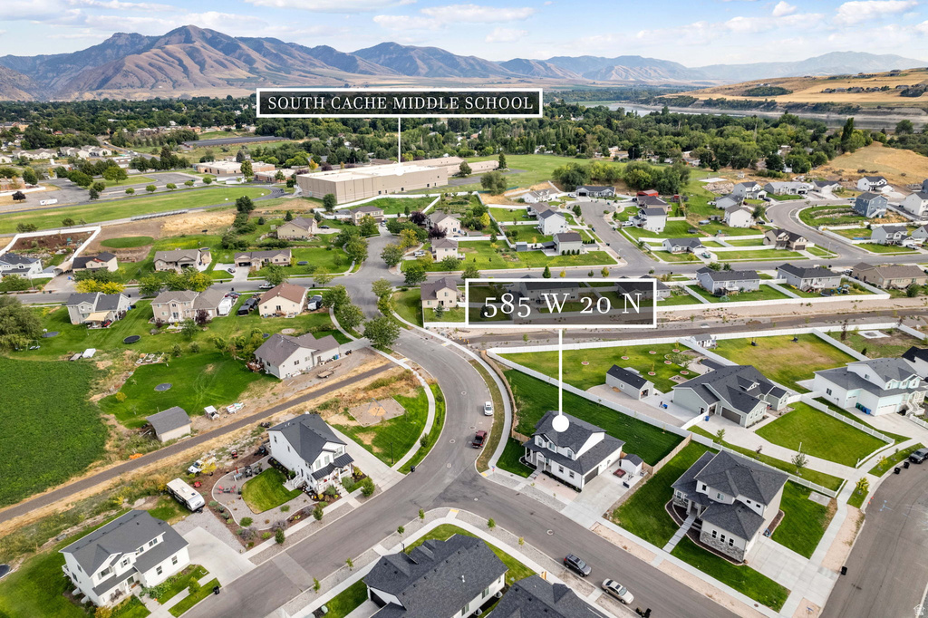Aerial perspective showcasing a residential neighborhood with mountain backdrops and a visible body of water