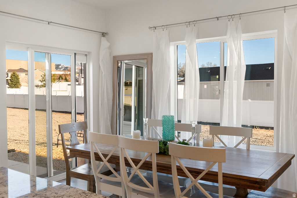 Bright dining area featuring a sliding glass door and multiple windows providing outdoor access and natural illumination