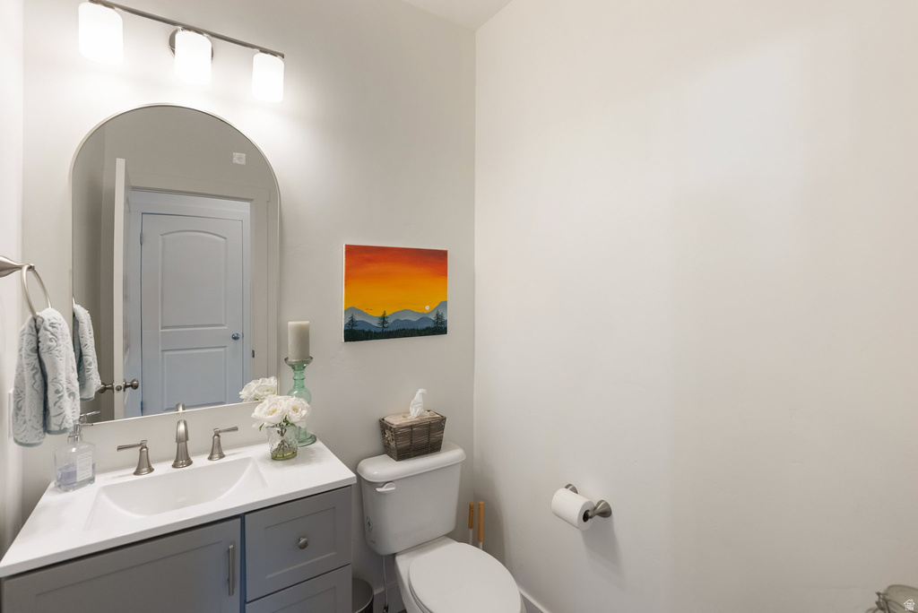 Bathroom featuring a single vanity with a gray cabinet, an integrated white sink, and a brushed nickel faucet