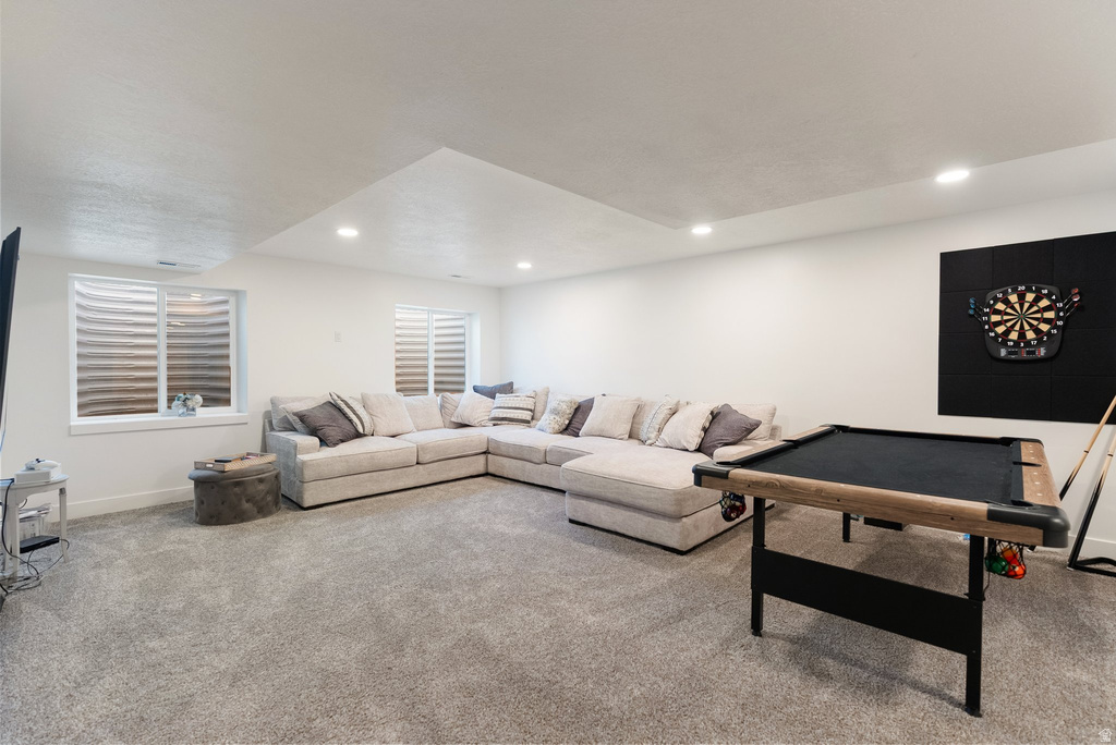 Spacious entertainment area featuring recessed lighting and light gray carpeting