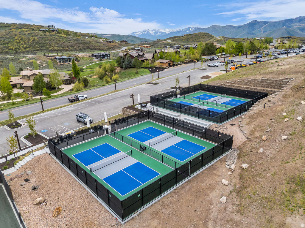 Multiple dedicated pickleball courts with black perimeter fencing and vibrant blue and green playing surfaces