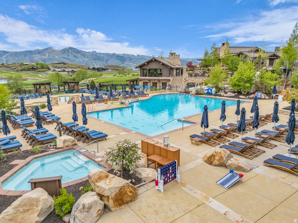 Expansive outdoor pool area featuring a large swimming pool, an integrated spa, and extensive surrounding patio space with lounge seating